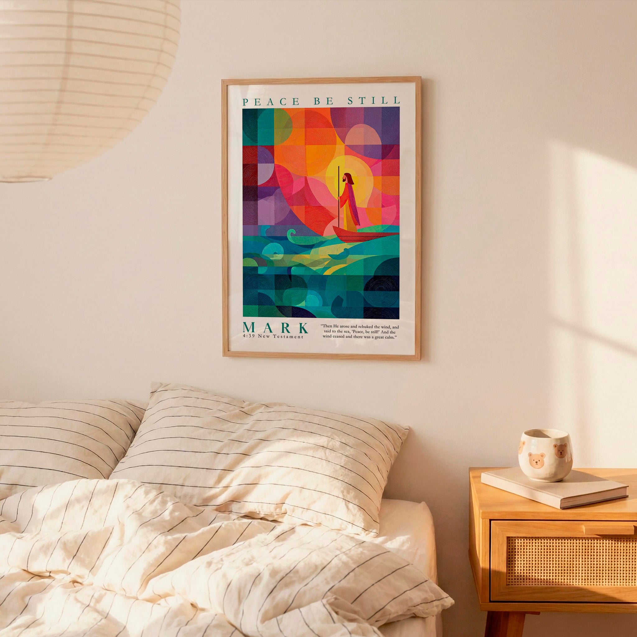 a poster of a woman in a colorful, abstract design hanging on a wall above a bed with striped pillows.