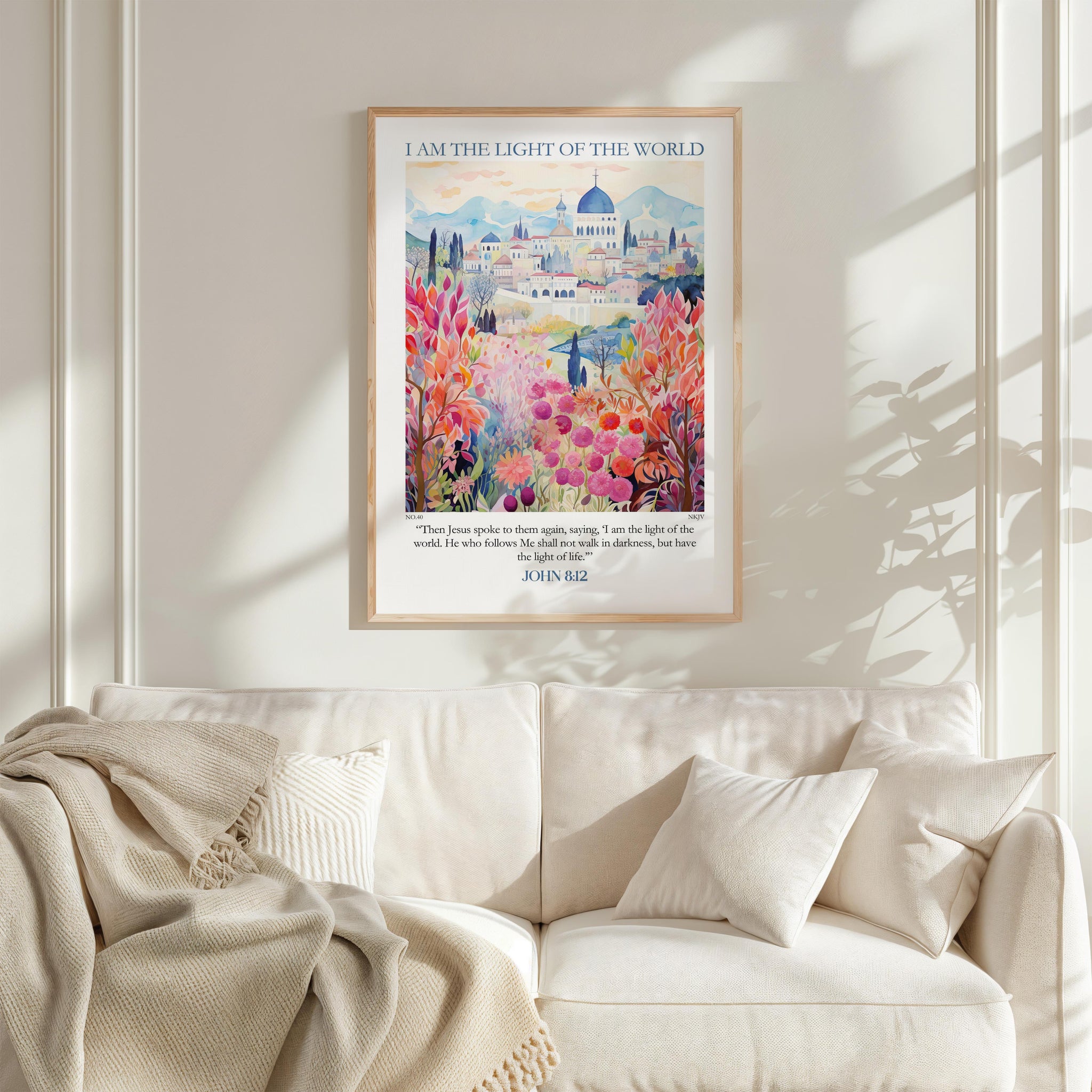 a framed poster of a colorful, floral-themed cityscape hanging on a wall above a white couch.