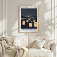 a framed poster of a nighttime scene with numerous lit lanterns, hanging on a wall above a white couch with a blanket draped over it.
