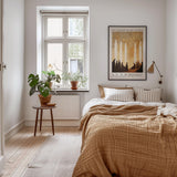 a cozy bedroom with a large bed, a nightstand, and a potted plant. The room has a warm, inviting atmosphere with a wooden floor and a window overlooking the outside.