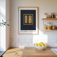 a kitchen counter with a bowl of lemons, a framed poster of a window with a lit candle, and shelves displaying various jars and containers.