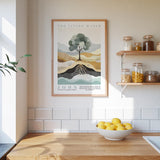 a kitchen counter with a bowl of lemons, a framed poster of a tree, and a shelf with jars and containers.