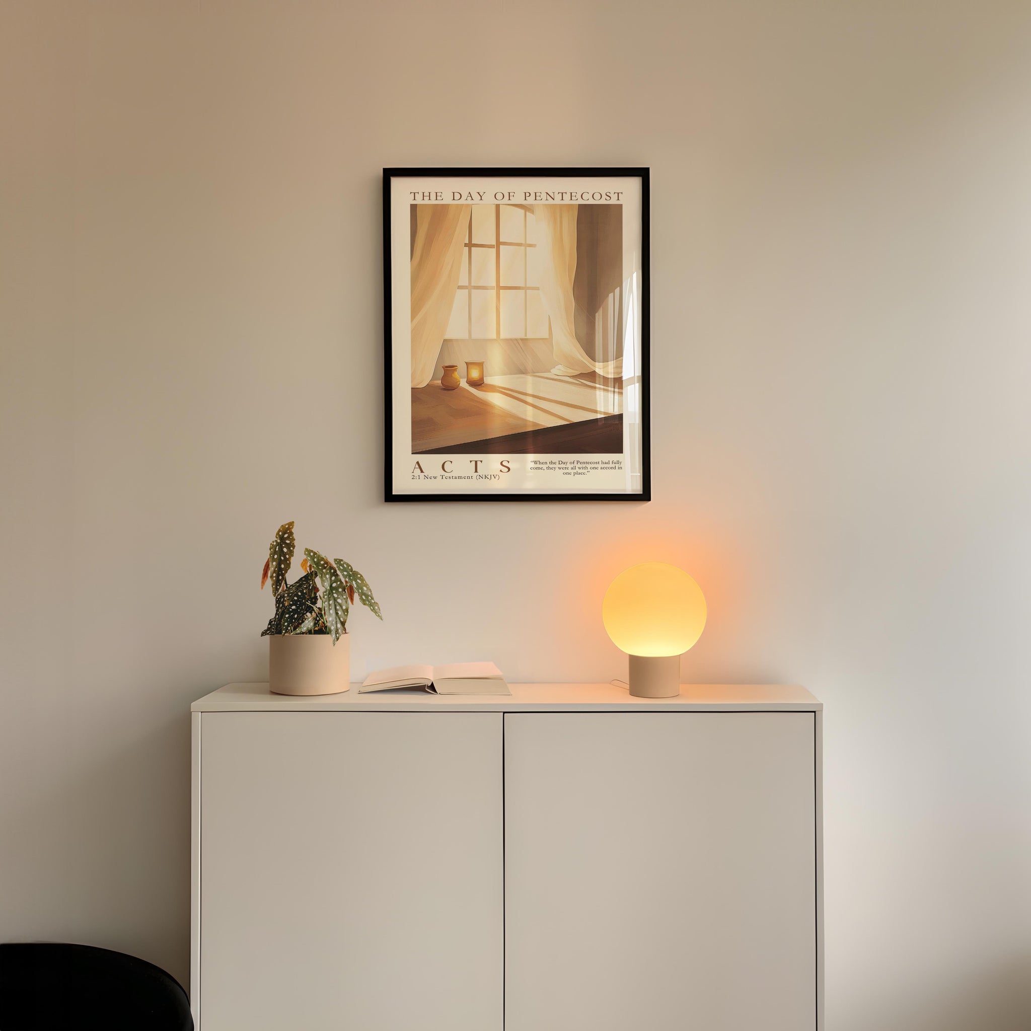 a minimalist interior design with a framed poster of a window and curtains, a small potted plant, and a white cabinet with a lamp on top.