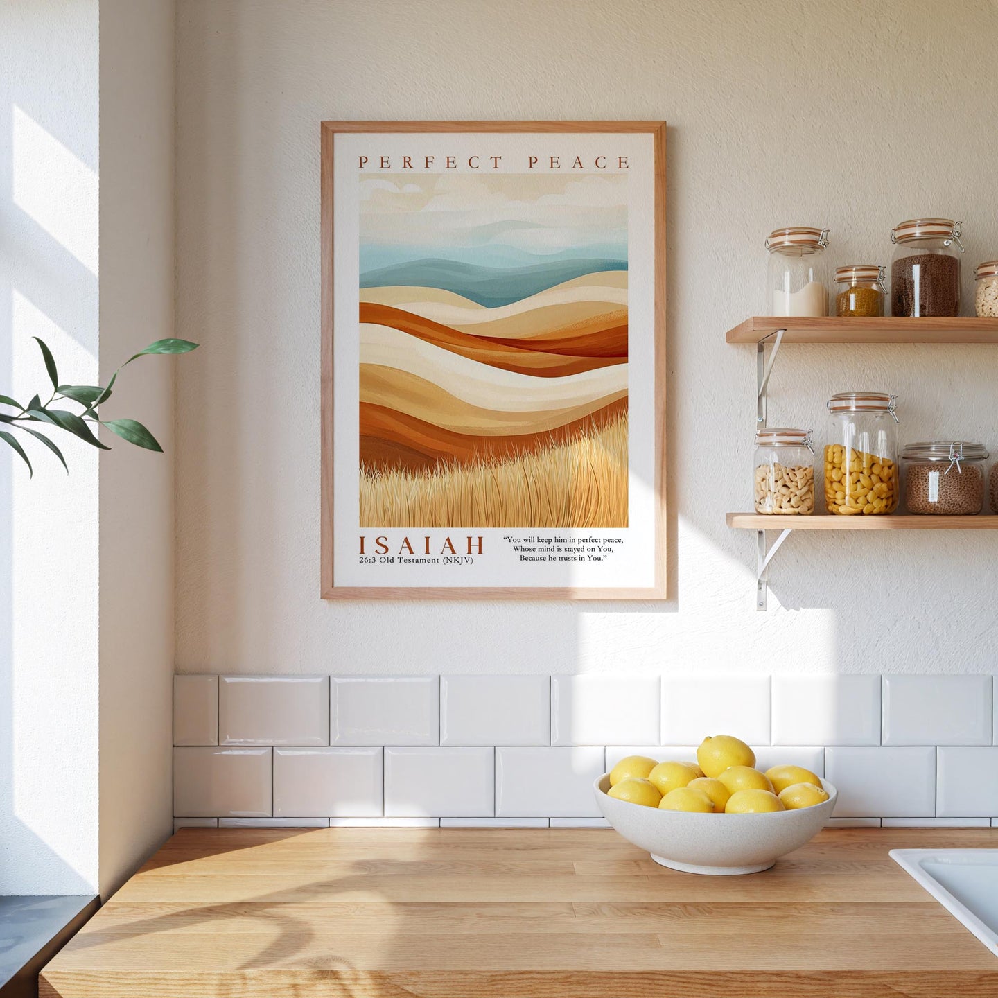 a kitchen counter with a bowl of lemons, a framed poster of a landscape, and a shelf with jars and containers.