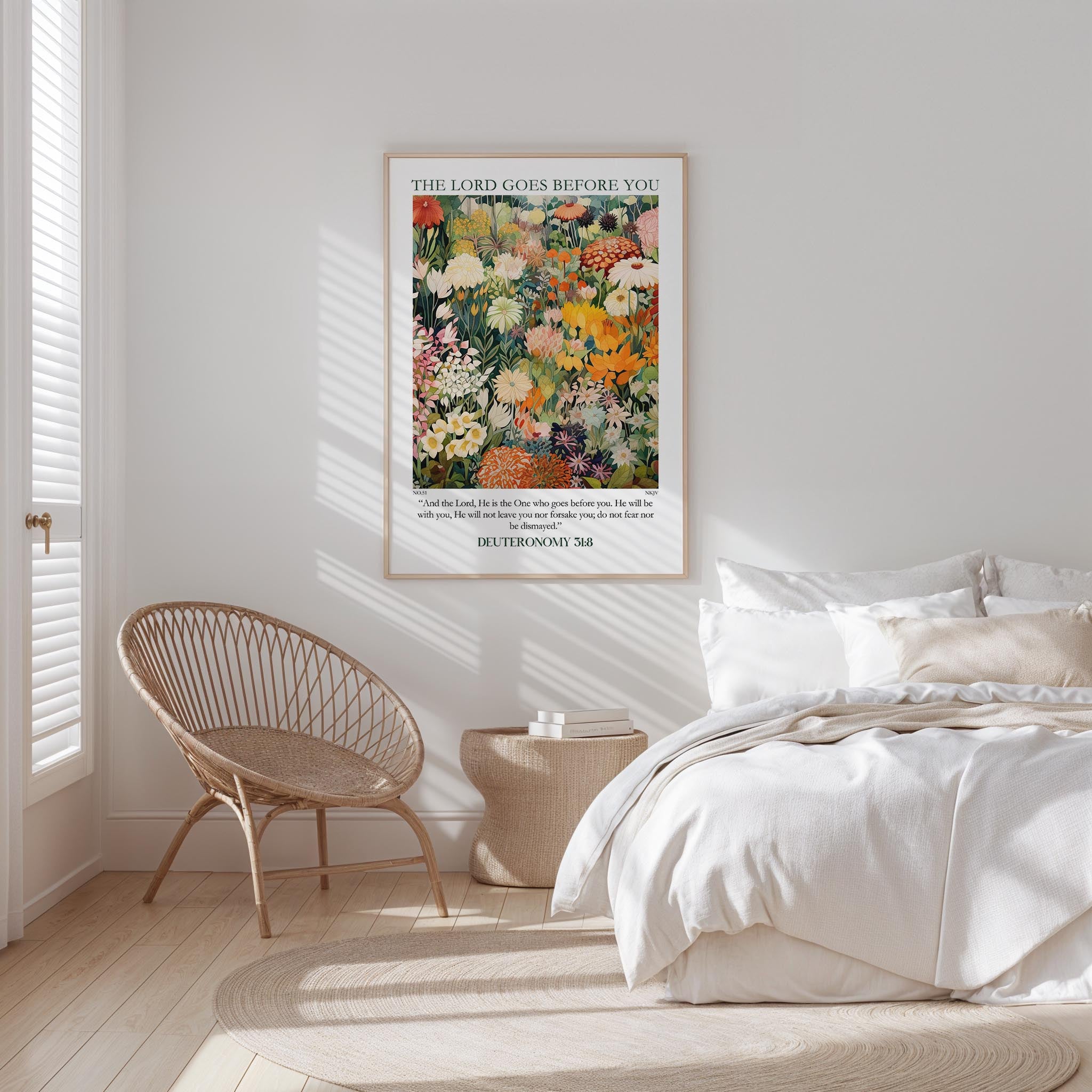 a serene bedroom scene with a bed, a woven chair, and a framed poster of a colorful floral painting on the wall.