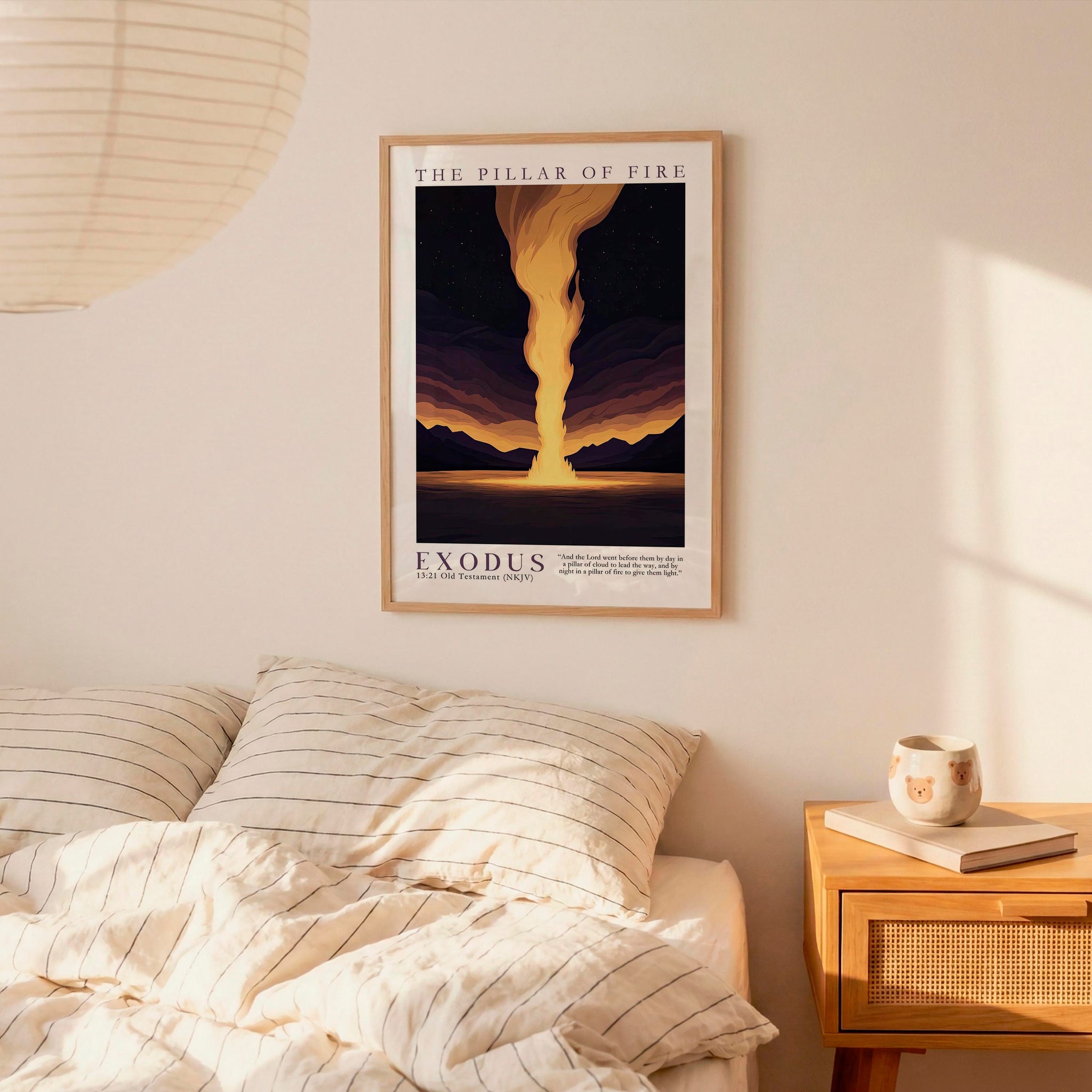 a bedroom scene with a framed poster of a sunset landscape hanging on the wall above a bed with striped bedding.
