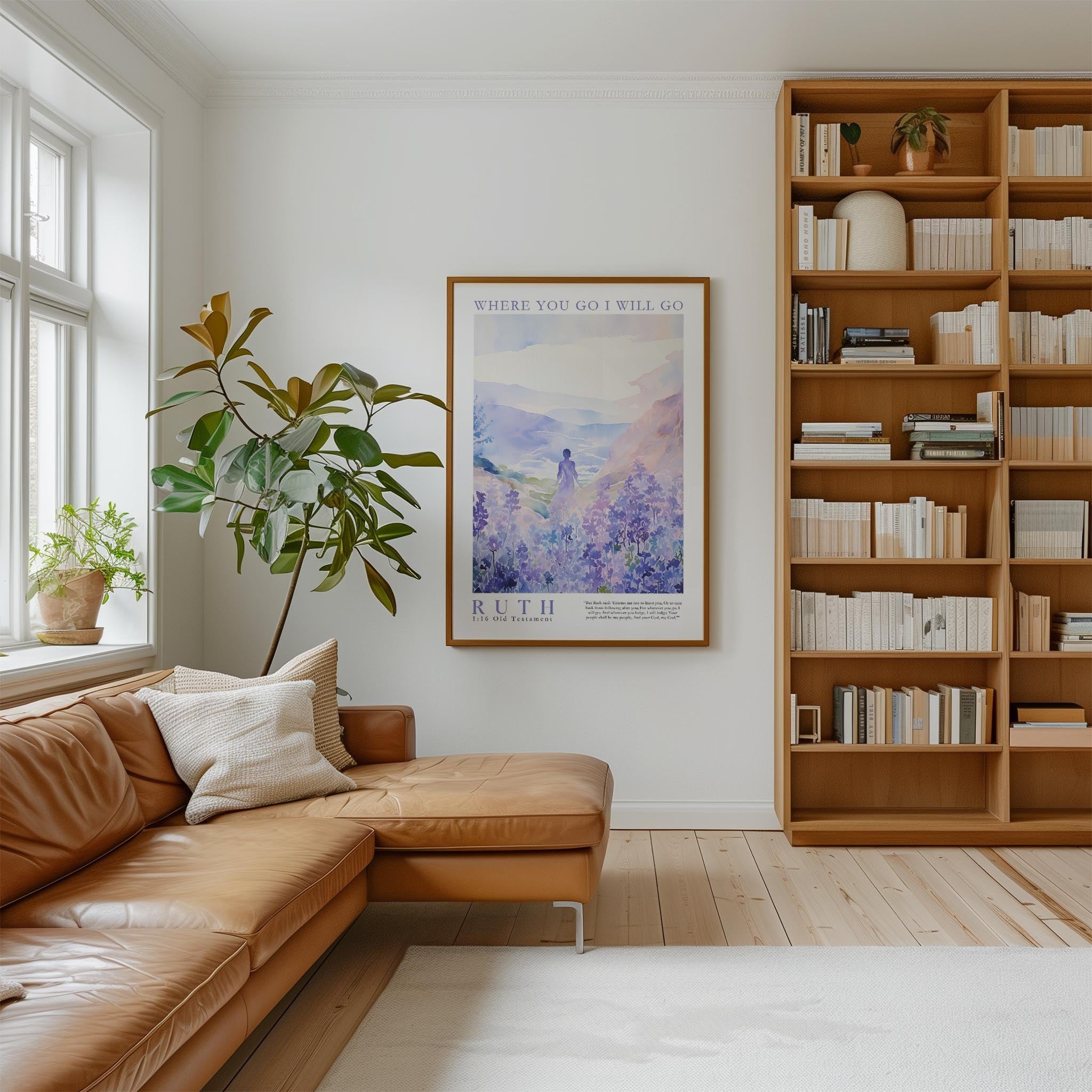 a cozy living room with a large window, a comfortable leather couch, a wooden bookshelf filled with books, and a framed poster of a mountain landscape hanging on the wall.