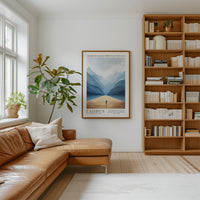 a cozy living room with a large bookshelf filled with books, a comfortable leather couch, and a framed poster of a mountain landscape hanging on the wall.