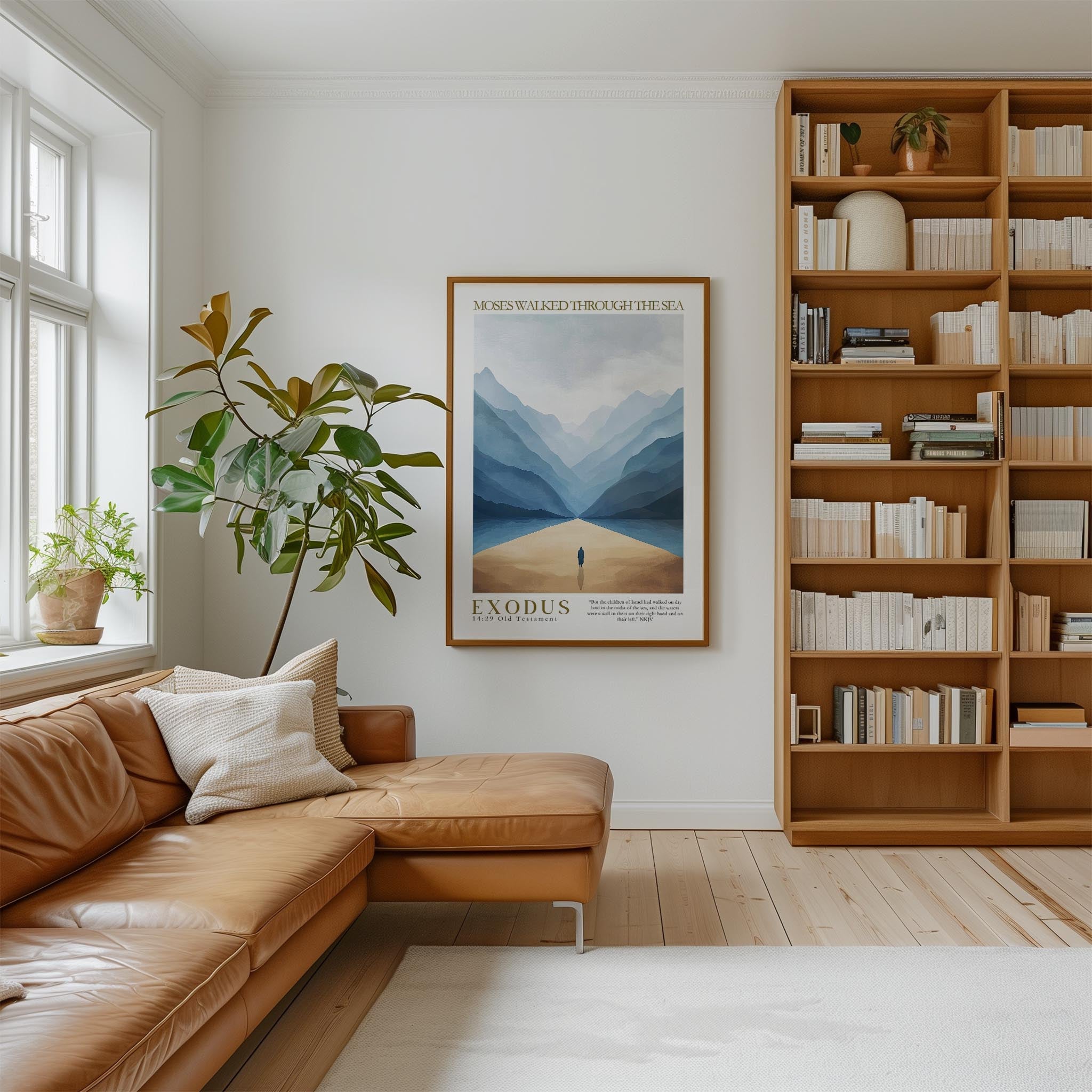 a cozy living room with a large bookshelf filled with books, a comfortable leather couch, and a framed poster of a mountain landscape hanging on the wall.