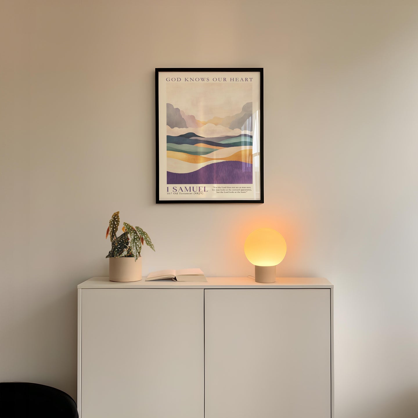 a minimalist interior design with a framed landscape poster on the wall above a white cabinet, which has a plant and a lamp on top of it.