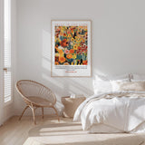 a bedroom with a bed, a woven chair, and a framed poster on the wall.