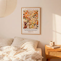 a bedroom setting with a framed poster of a floral design hanging on the wall above a bed with striped bedding.