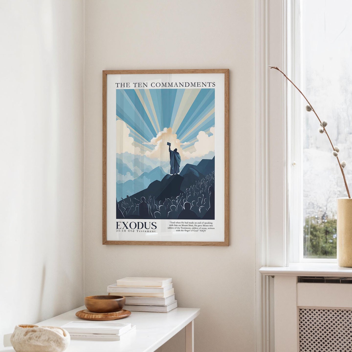 a framed poster of a mountain landscape with a figure standing on top, along with the text "THE TEN COMMANDMENTS" and "EXODUS".