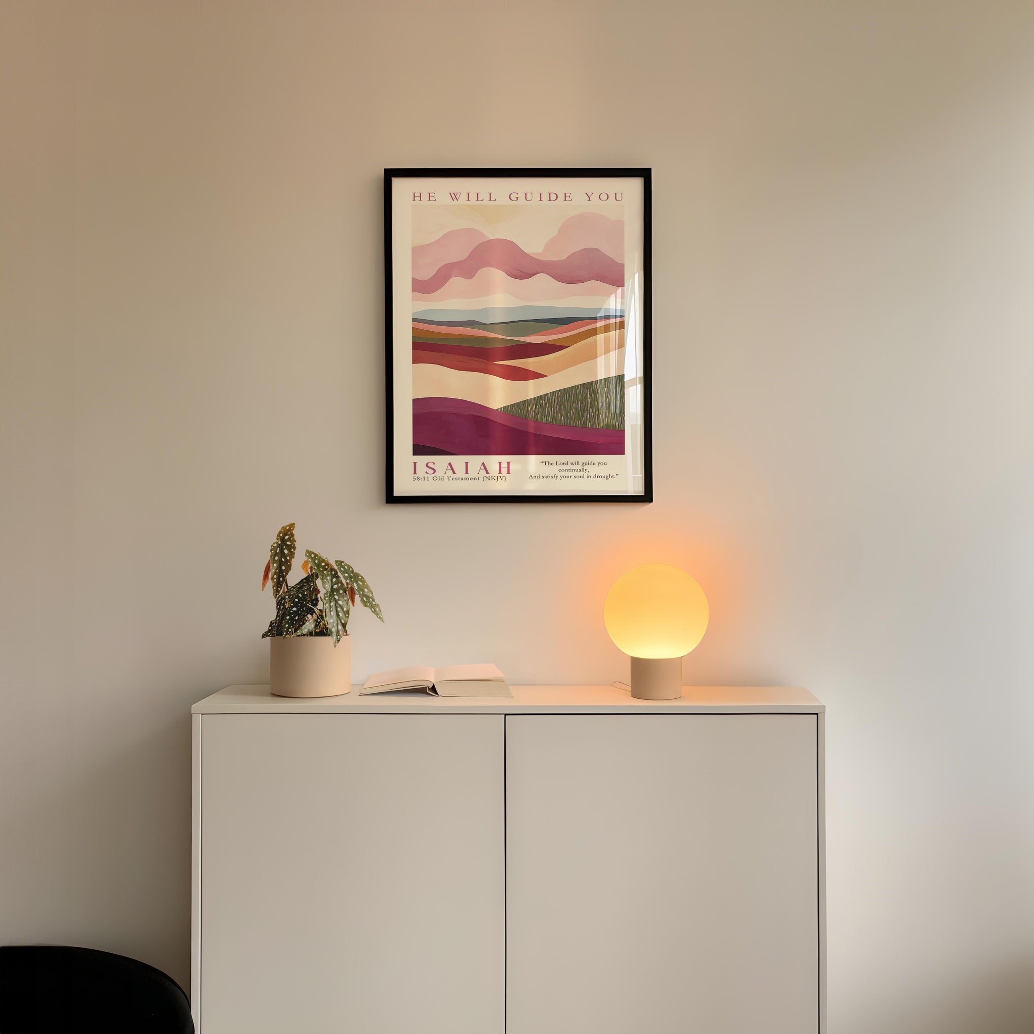 a minimalist interior design with a framed poster of a landscape, a potted plant, and a small lamp on a white cabinet.