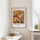 a framed poster of a colorful floral design hanging on a wall, with a quote from Proverbs 3:5 below it.