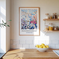 A framed poster with a colorful illustration of a cityscape hangs on a wall above a wooden countertop with a bowl of lemons.