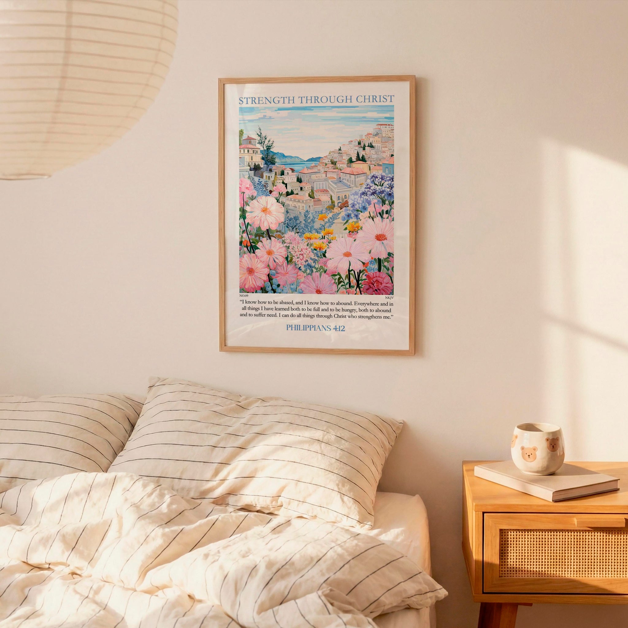 a bedroom scene with a framed poster of a colorful floral landscape hanging on the wall above a bed with striped pillows.