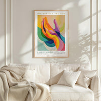 a vibrant abstract painting hanging on a white wall above a white couch with a blanket draped over it.