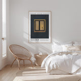 A bedroom with a bed, a woven chair, and a framed poster on the wall.