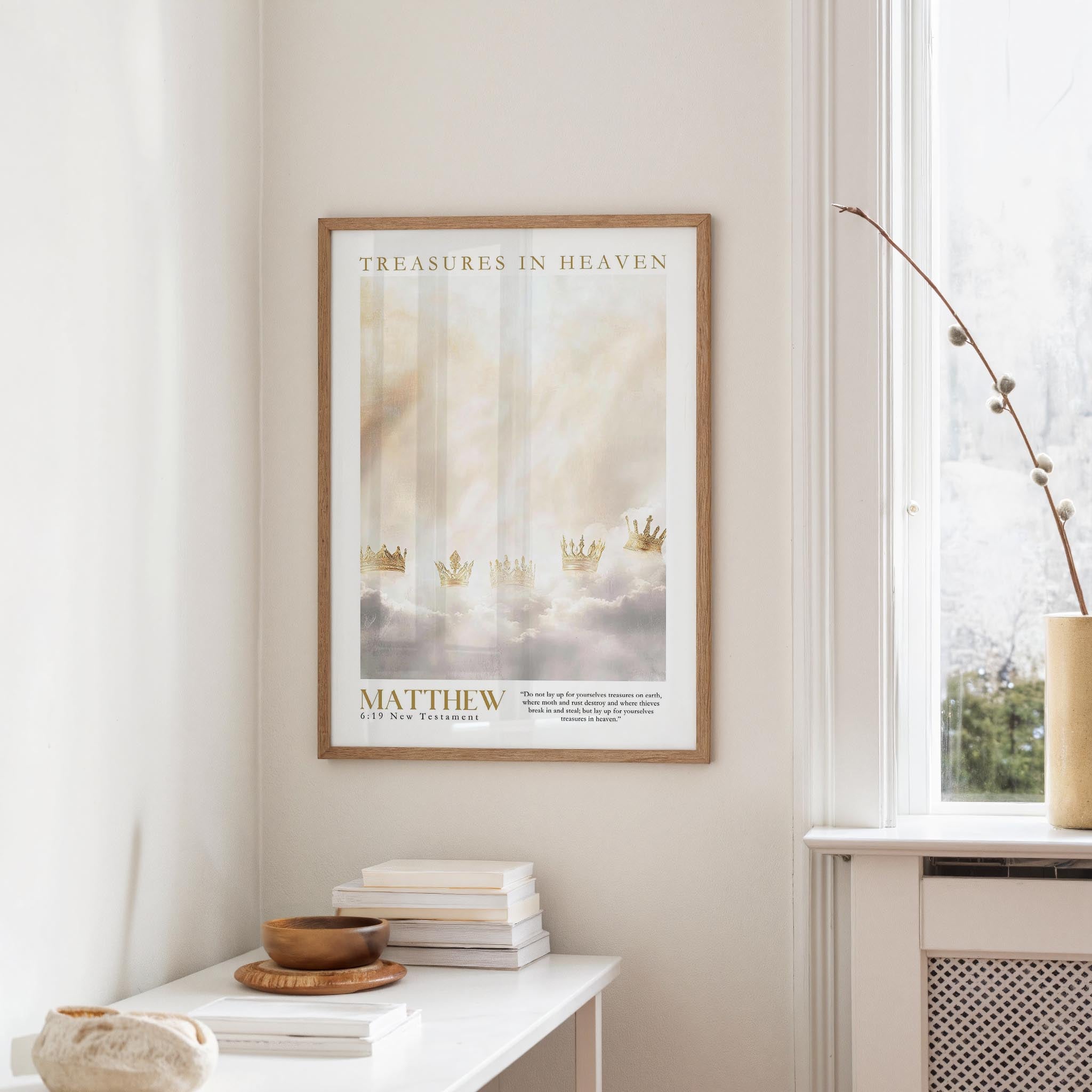 a framed poster of a serene landscape with clouds and crowns, hanging on a wall in a room with a white table and a window.