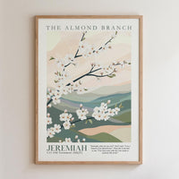 The image is a framed poster featuring a floral design with white flowers against a background of green hills and mountains. The poster is titled "The Almond Branch" and includes a biblical verse from the book of Jeremiah.