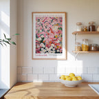 a kitchen scene with a framed poster of a colorful floral design hanging on the wall above a wooden countertop with a bowl of lemons.