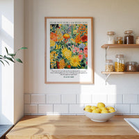 a kitchen scene with a framed poster of a colorful garden hanging on the wall above a wooden countertop with a bowl of lemons.