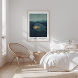 a bedroom with a bed, a woven chair, and a framed poster of a whale on the wall.