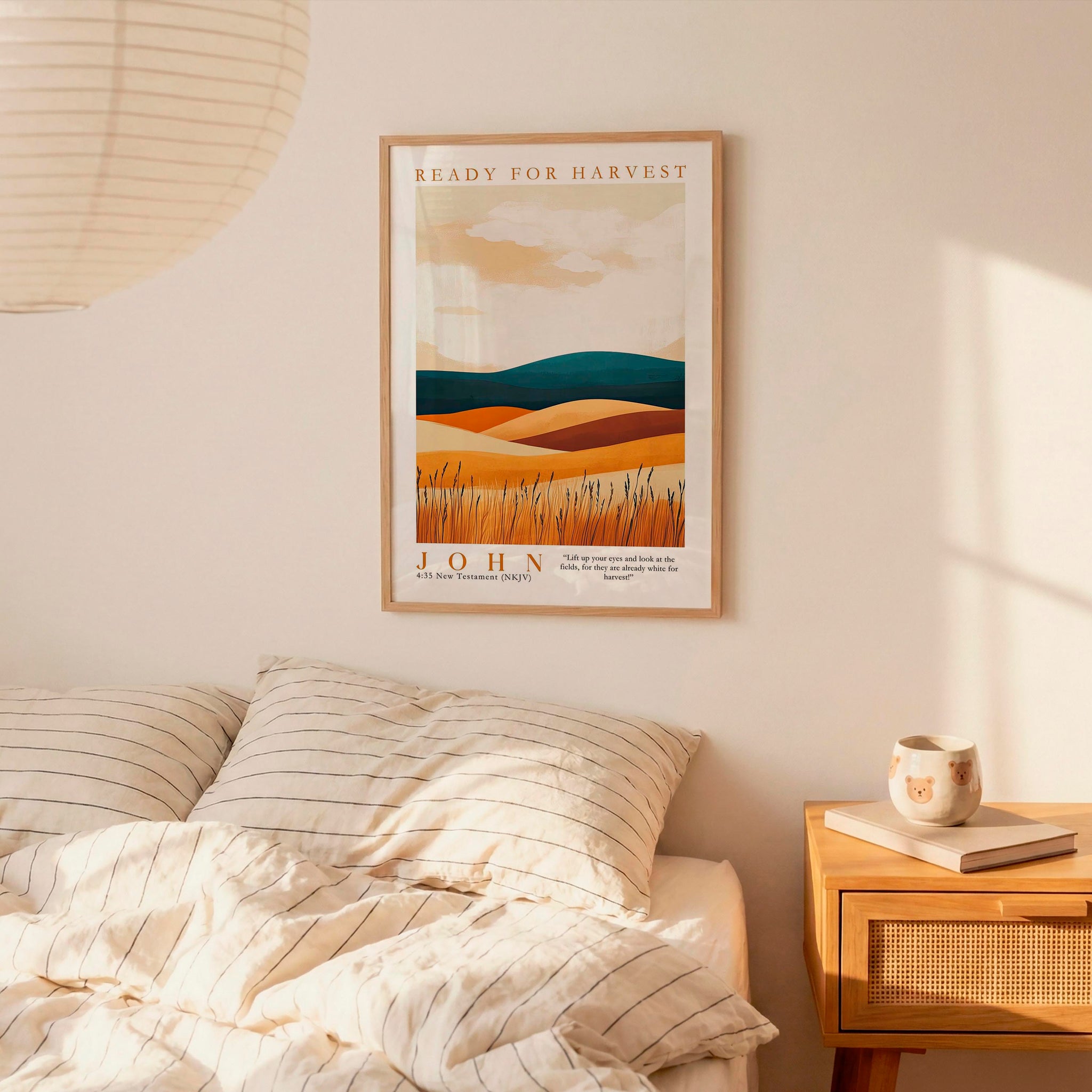 a bedroom scene with a framed poster of a landscape hanging on the wall above a bed with striped pillows.
