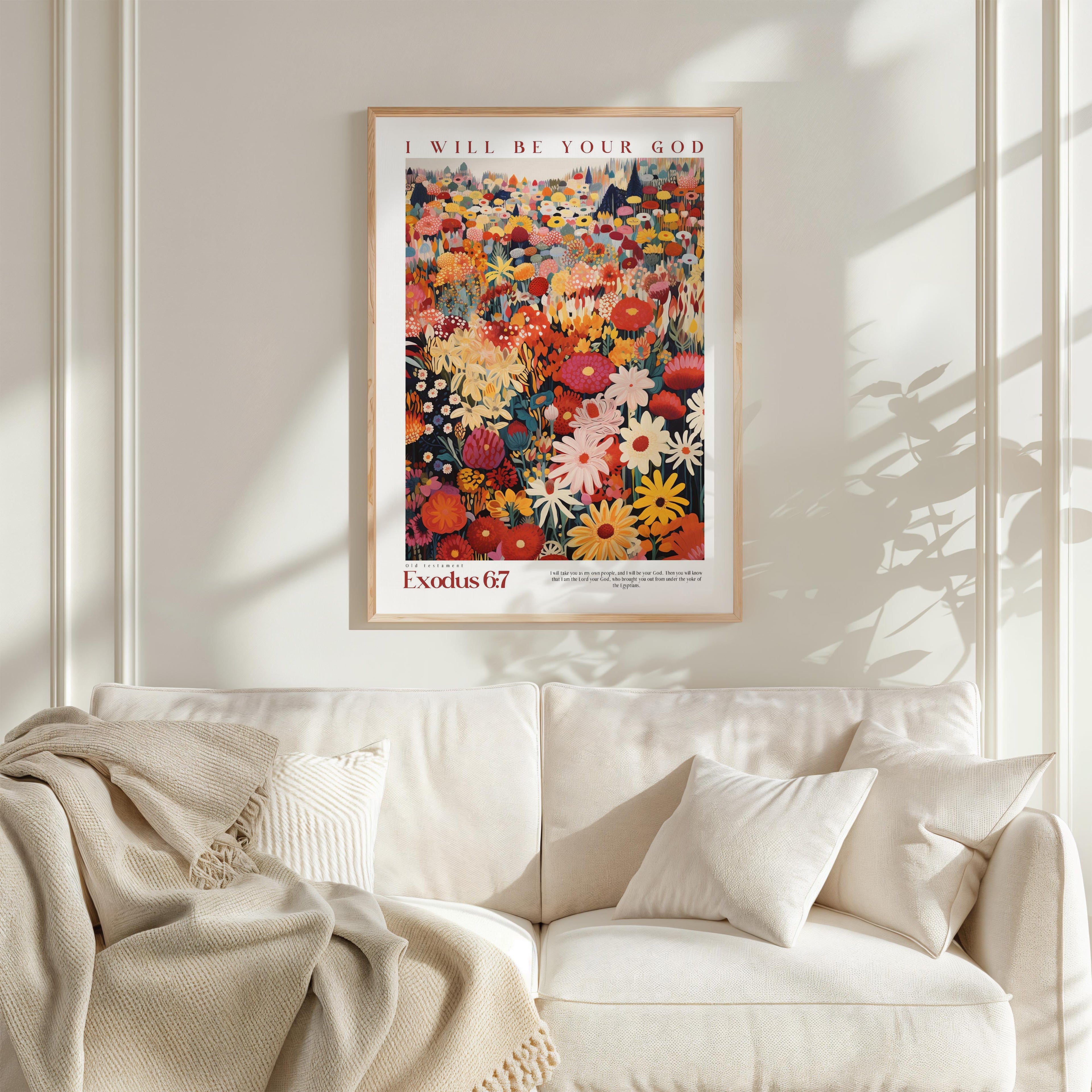 a framed poster of a colorful floral arrangement hanging on a wall above a white couch with a blanket draped over it.