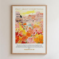 The image is a framed poster with a vibrant illustration of a cityscape filled with colorful flowers. The poster has a religious message and a Bible verse from Philippians 4:6.