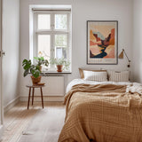 a cozy bedroom with a large bed, a wooden nightstand, and a window with a plant on it. The room has a warm, inviting atmosphere with a neutral color palette and natural elements like the potted plant and the rug.