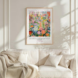 a vibrant, colorful poster of a garden scene hanging on a white wall above a white couch.