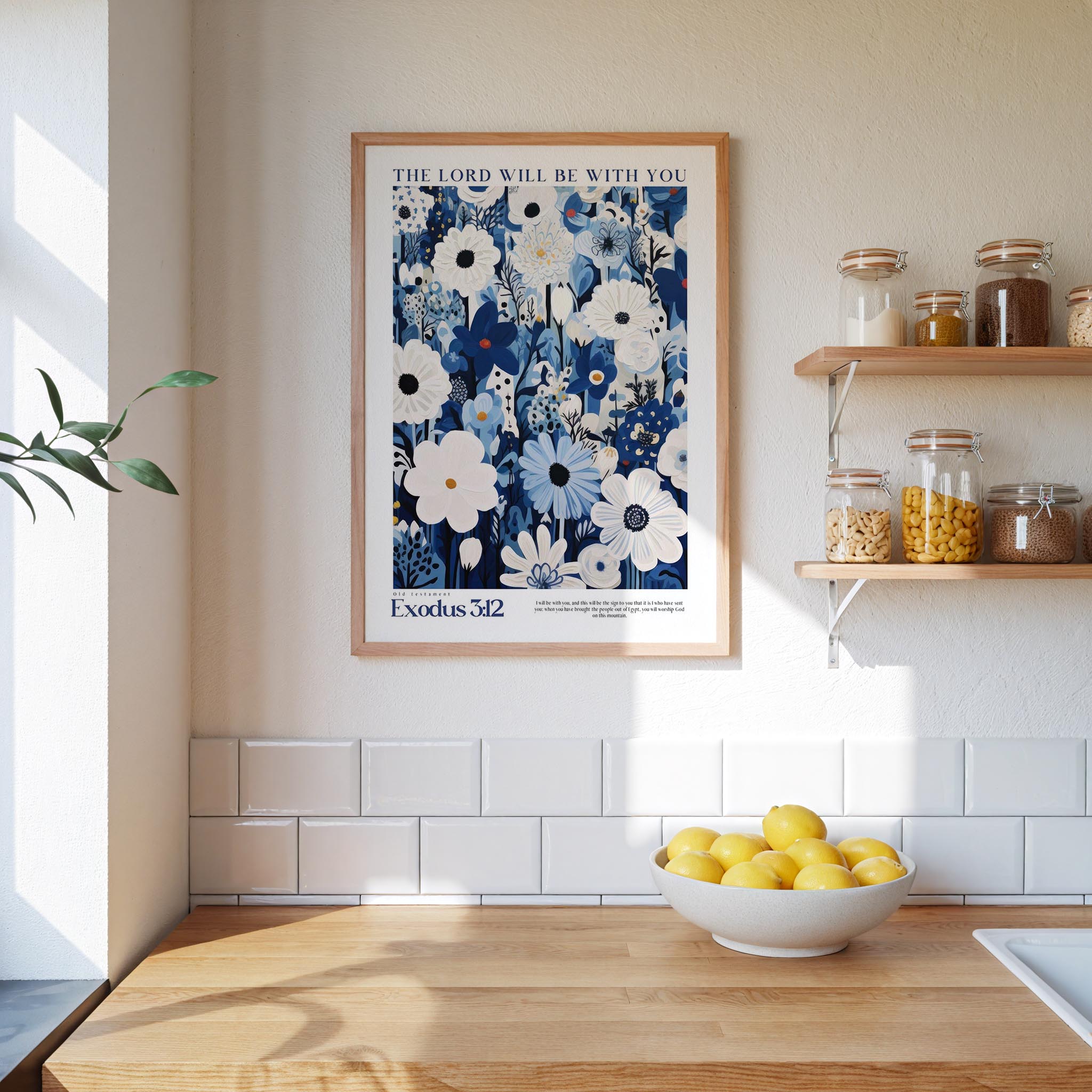 a kitchen scene with a framed poster of a blue floral design hanging on the wall above a wooden countertop with a bowl of lemons.