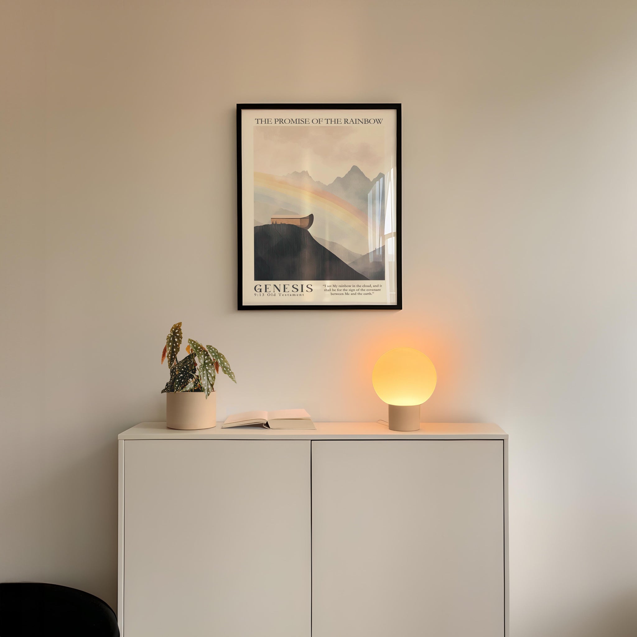 a minimalist interior design with a framed poster of a mountain landscape above a white cabinet with a plant and a lamp on top.