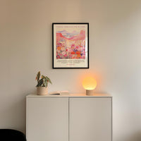 a white cabinet with a potted plant and a lamp on top, set against a white wall.