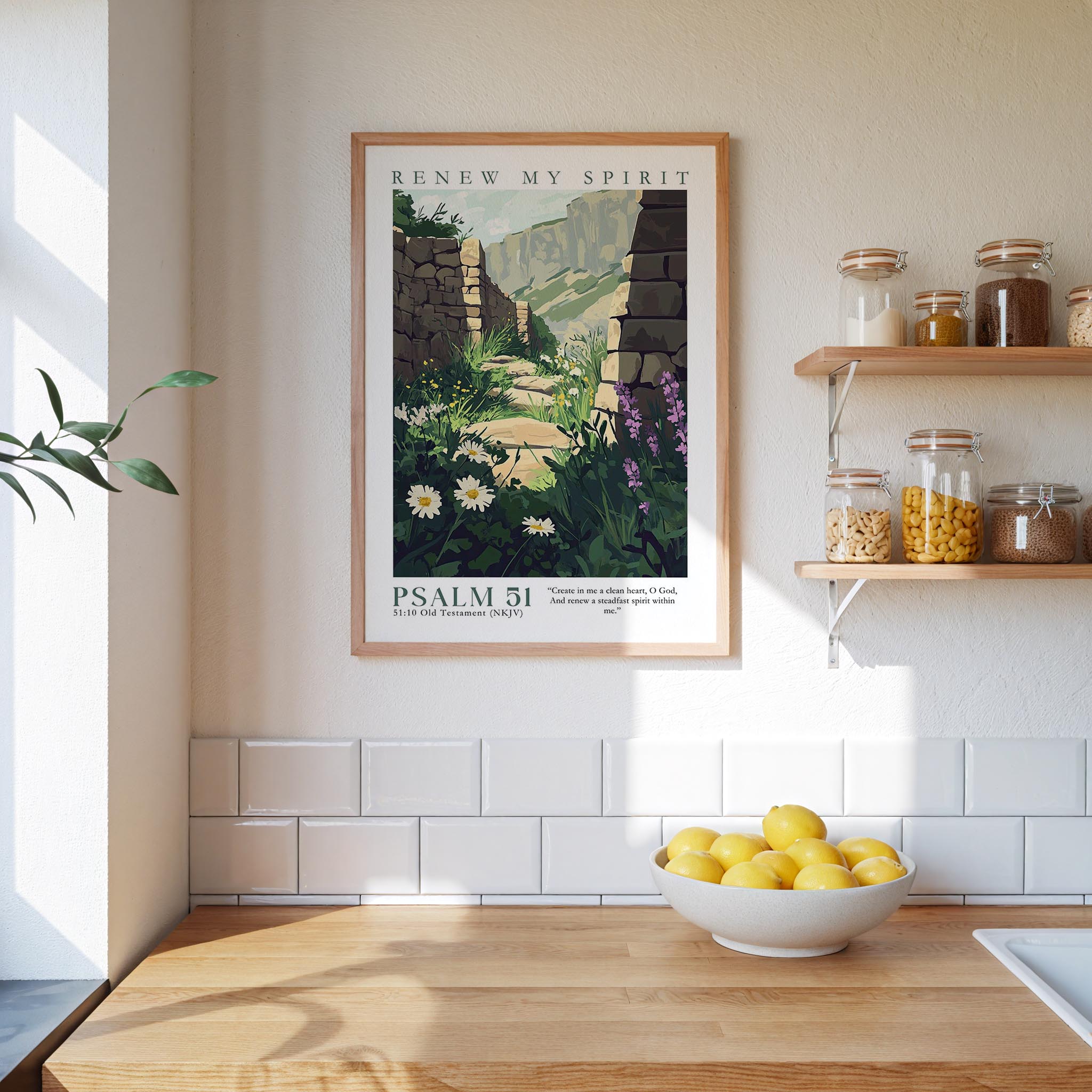 a kitchen scene with a framed poster of a garden hanging on the wall above a wooden countertop with a bowl of lemons.