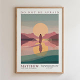 The image is a framed poster with a minimalist illustration of a person walking on a beach, with mountains in the background and a sunset. The text on the poster reads "DO NOT BE AFRAID" and "MATTHEW 2447 NEW TESTAMENT".