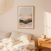 a bedroom scene with a framed poster of a mountain landscape hanging on the wall above a bed with striped bedding.
