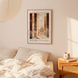 a bedroom setting with a bed, a nightstand, and a poster on the wall. The poster is a framed artwork depicting a person walking through a hallway.