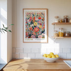 a kitchen scene with a framed poster of a colorful floral design hanging on the wall above a wooden countertop with a bowl of lemons.