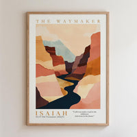 The image is a framed poster featuring an abstract landscape with mountains and a winding river. The poster is titled "The Waymaker" and includes a biblical verse from Isaiah 43:19, which reads "I even make a road in the wilderness and rivers in the desert."