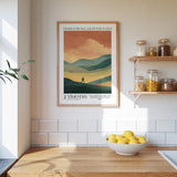 a kitchen counter with a bowl of lemons, a framed poster of a mountain landscape, and a shelf with jars and bottles.