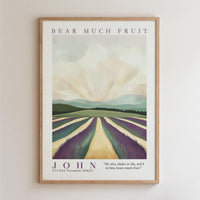 The image is a framed poster featuring a landscape with a field of purple flowers and a mountain range in the background. The poster has a vintage style and is framed in a wooden frame.