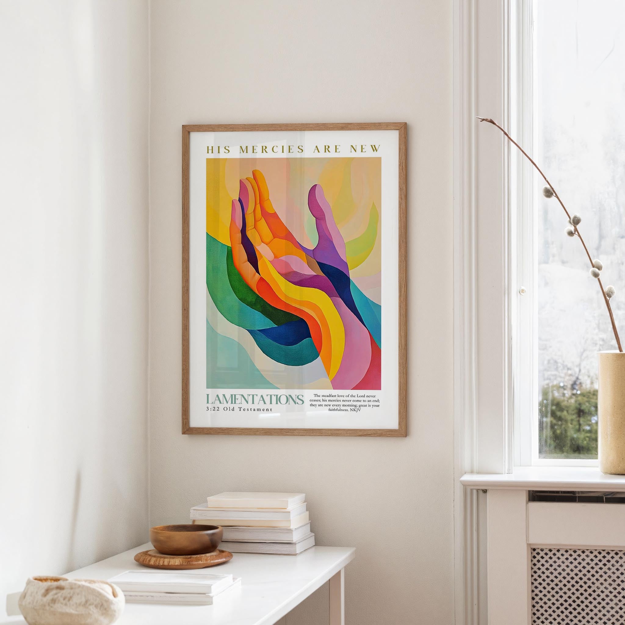 a colorful abstract painting hanging on a wall, with a stack of books and a vase on a table below it.