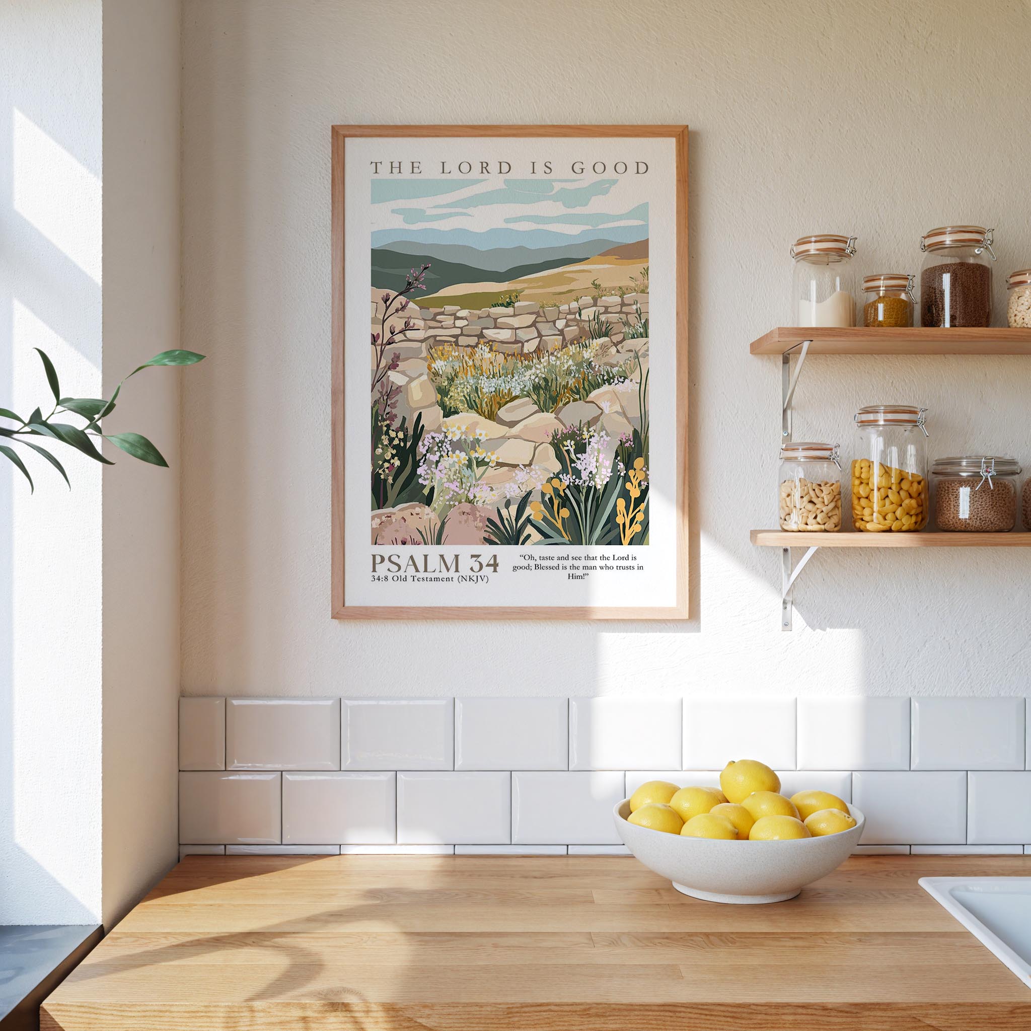 a kitchen scene with a framed poster of a desert landscape hanging on the wall above a wooden countertop with a bowl of lemons.