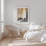 a serene bedroom scene with a bed, a woven chair, and a framed poster on the wall.