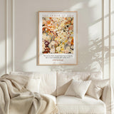a framed poster of a colorful floral painting hanging on a wall above a white couch with a blanket draped over it.