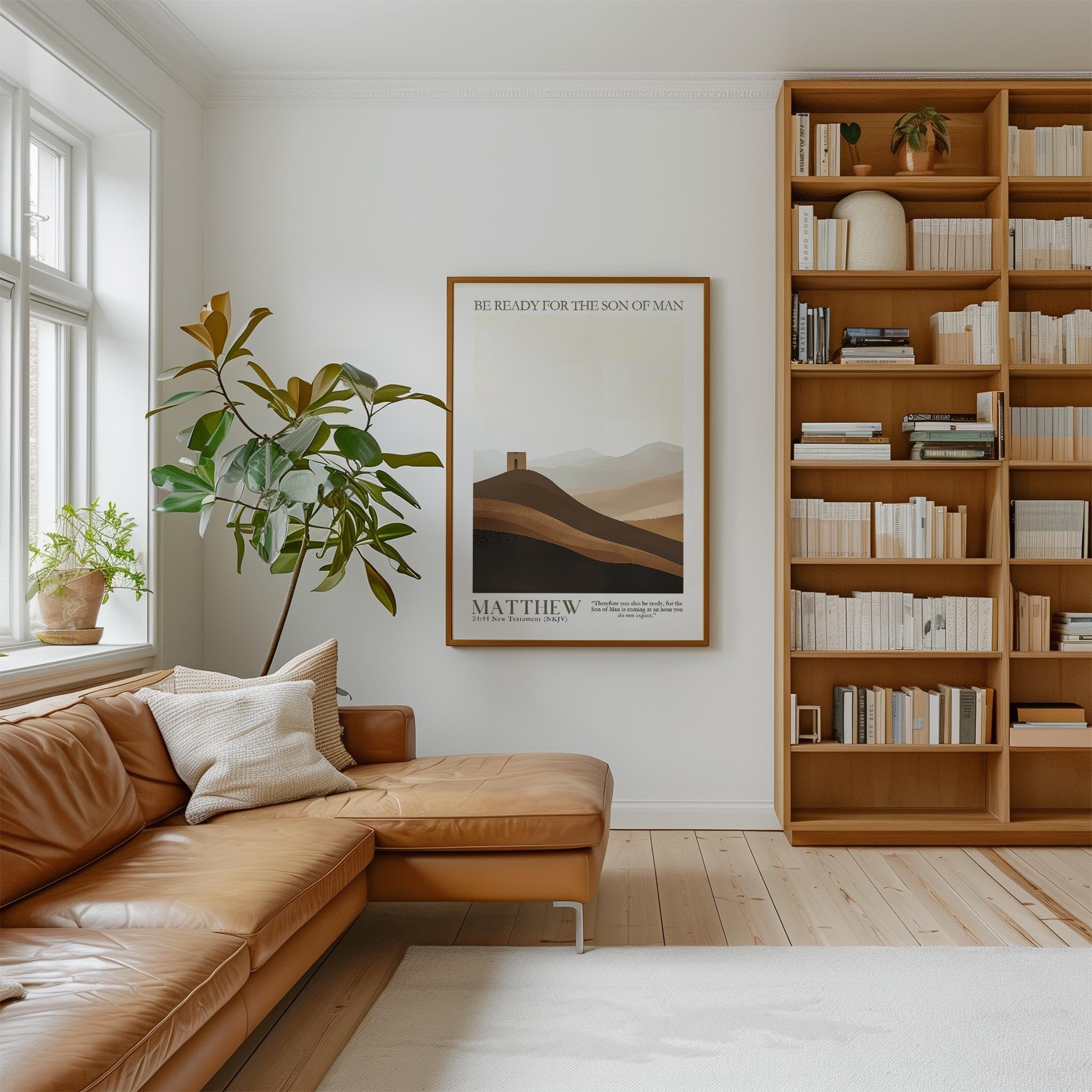 a cozy living room with a large bookshelf filled with books, a comfortable leather sofa, and a framed poster of a mountain landscape.