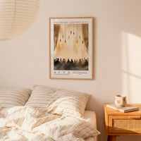 a bedroom setting with a framed poster of a group of people hanging on the wall above a bed with striped bedding.